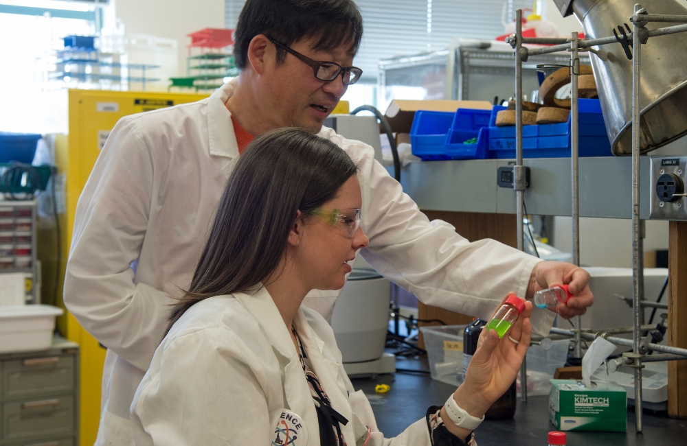 Dr. Pak engaging with student, Emily Morley in his chemistry lab.