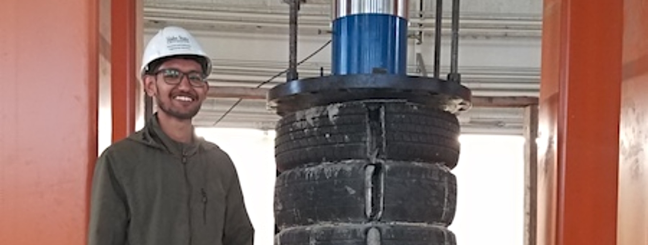 Student standing next to recycled tires