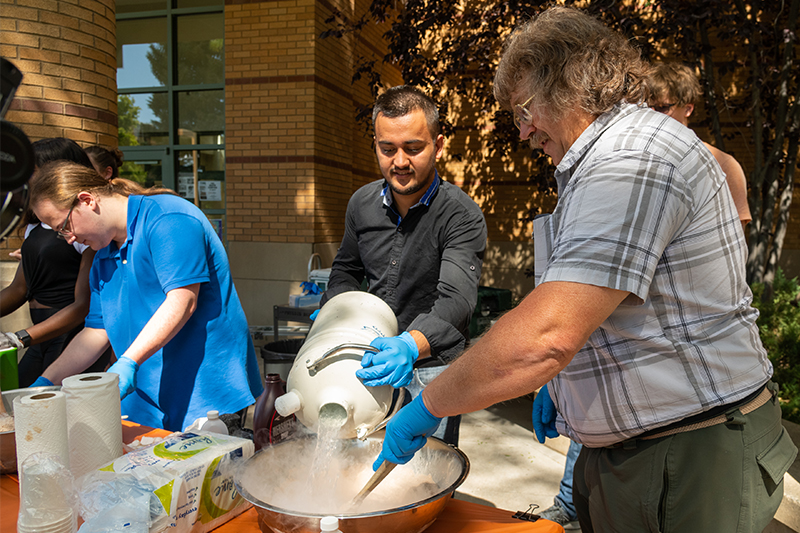 Steve Shropshire and a student make nitrogen ice cream at a physics demonstration.