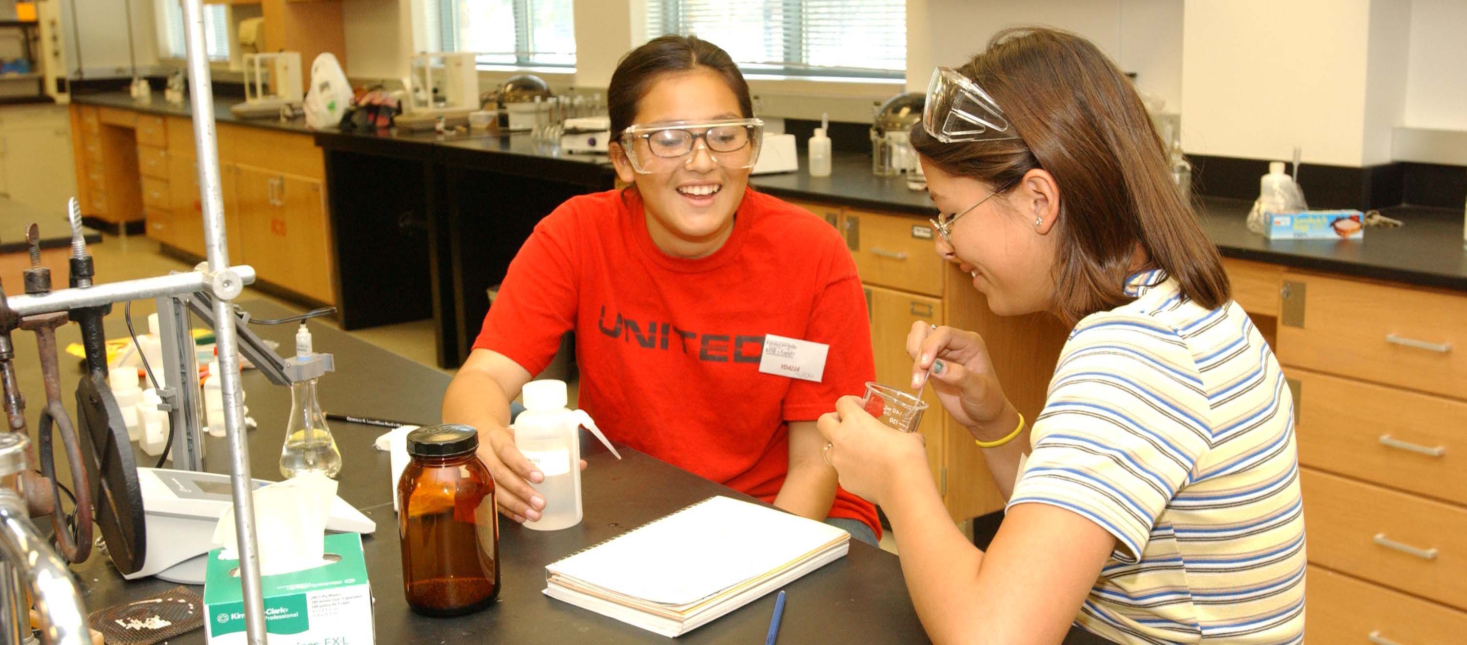 Two students with a scientific beaker