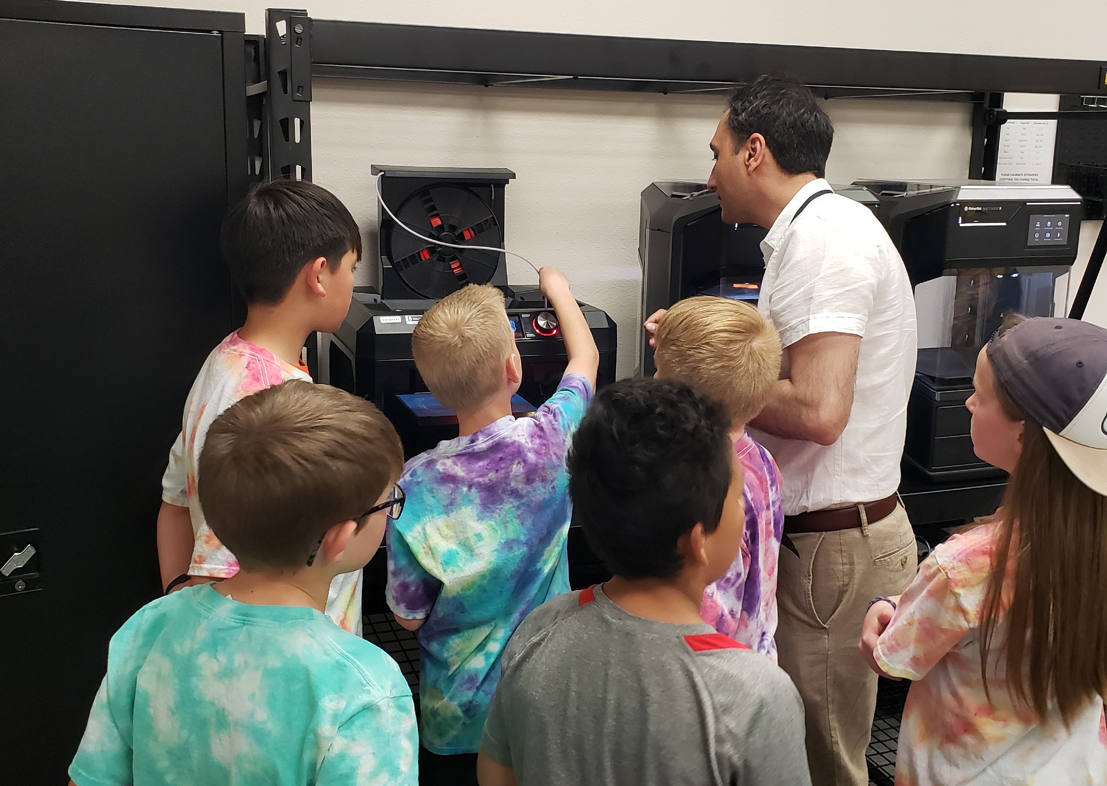 A fieldtrip of kids visiting the robotics lab