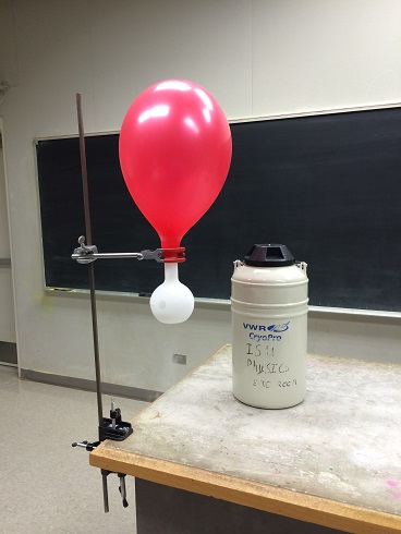 A balloon attached to a rod and has a small flask inside of it