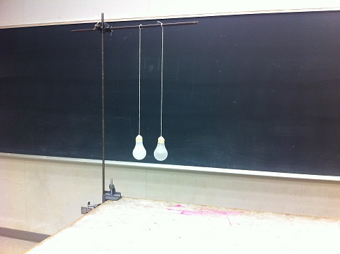 Two light bulbs hanging from a rod