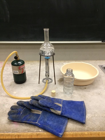 Heat gloves by a Bunsen burner that is boiling water in a flask