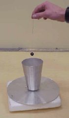 A ball on a string held over a metal cup