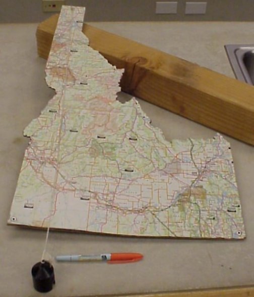 A cut out of Idaho attached to a string near the top