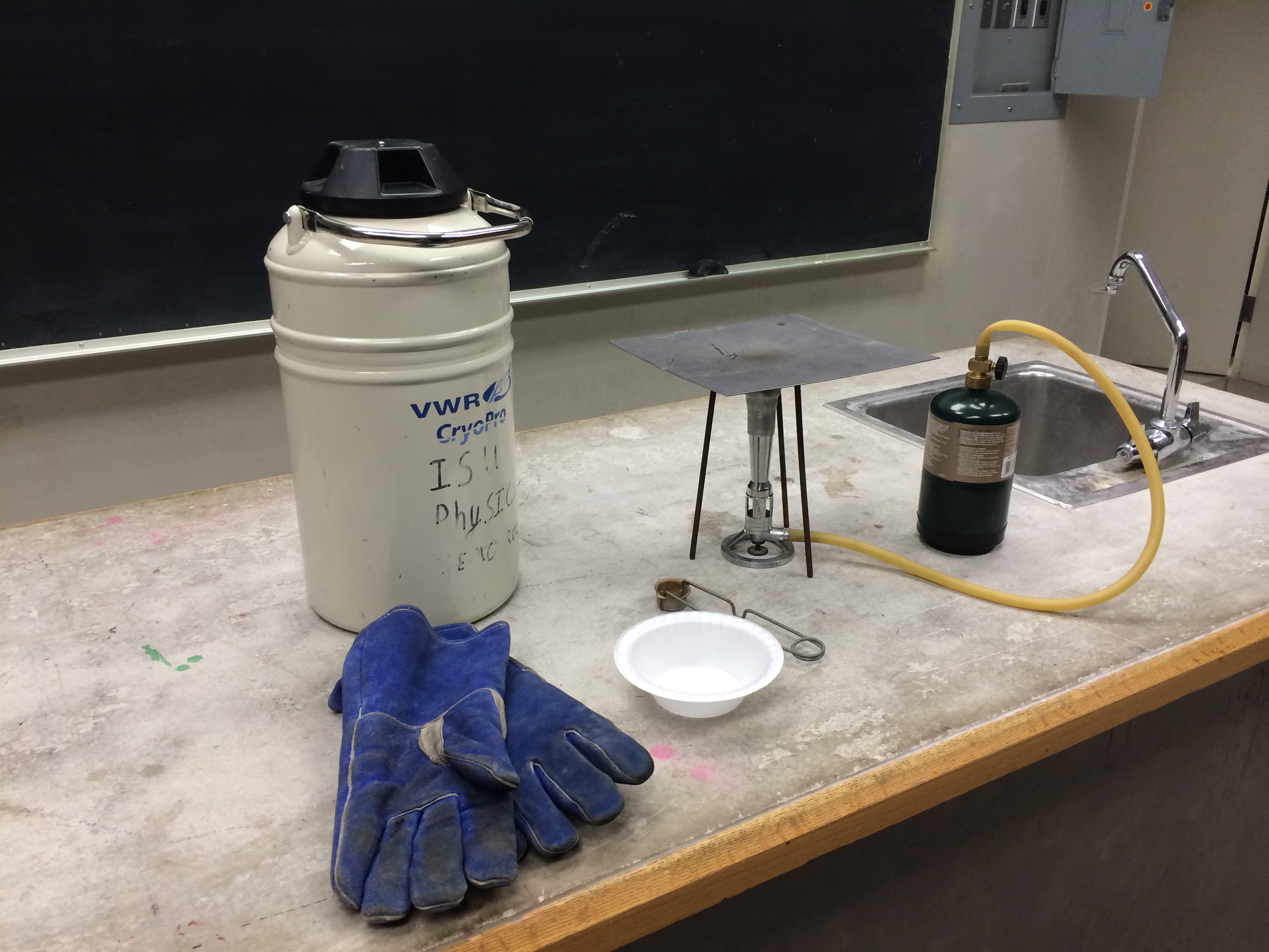 A bunsen burner next to a container of Liquid Nitrogen
