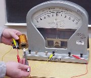 A galvanometer reading a magnet going through a coil