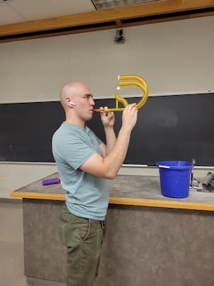 Someone blowing through a pipe system making balls float