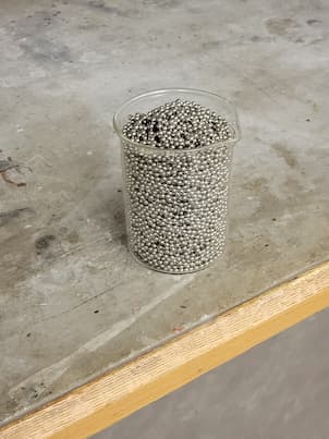 A beaker full of beads on a string