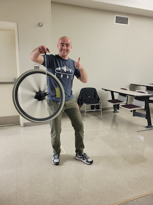 Someone holding a bicycle wheel while its holding itself up