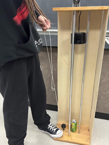 Student about to release a string and drop the pile driver.