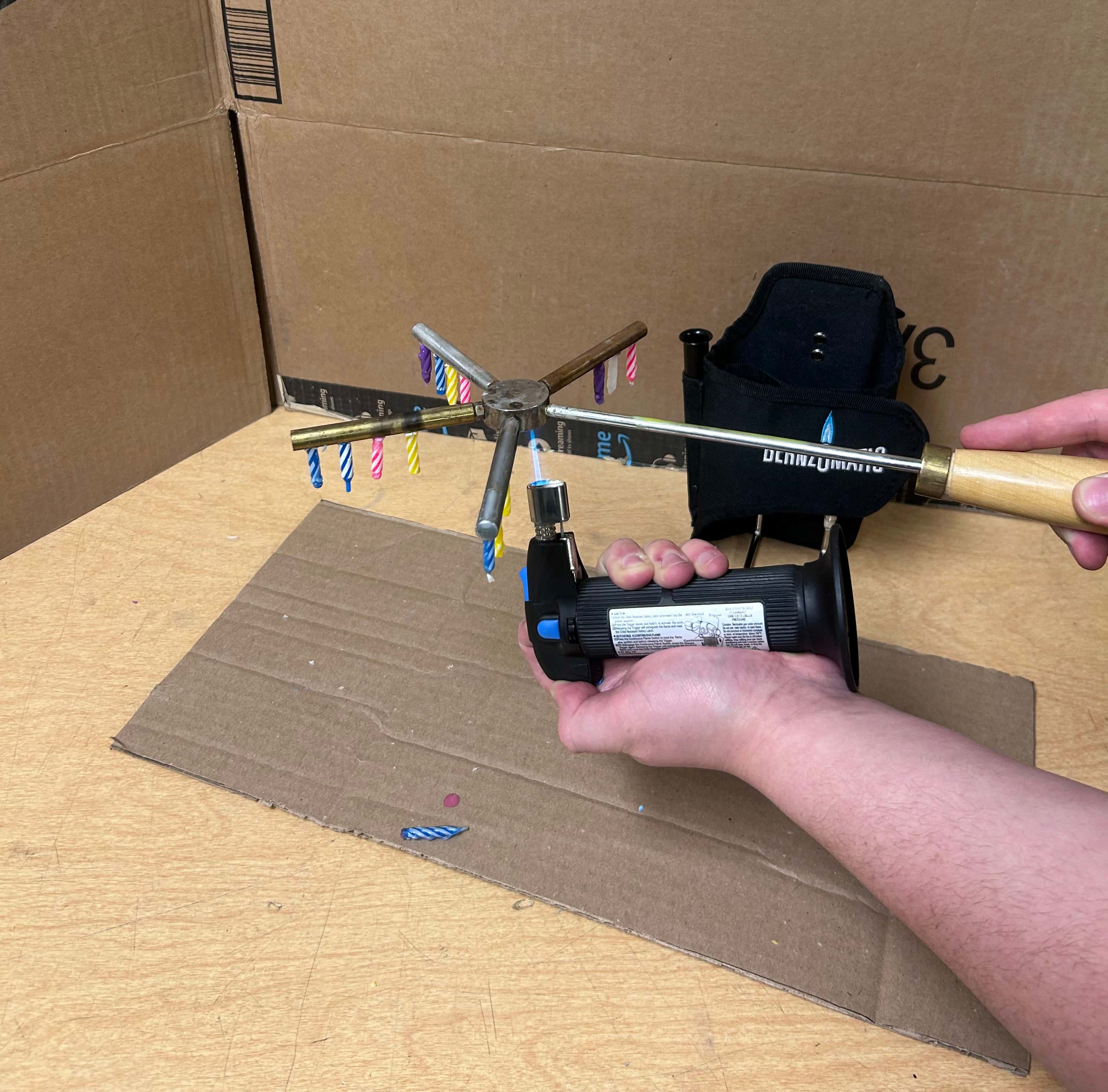 Performer holding the Conductometer aparatus and Bernzomatic torch for the manual setup.