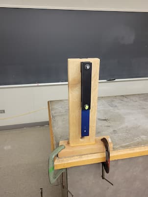 A wood piece clamped with 2 pendulums screwed to each other