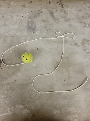 Tennis ball connected to a rope