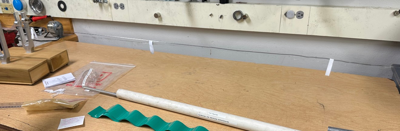 A couple folded strips of paper resting on a wire