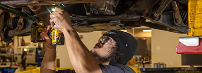 Automotive Technology student working under a car