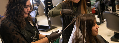 Cosmetology students working on a customers hair