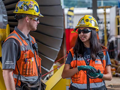 Man and Women in hardhats and safety vests talking