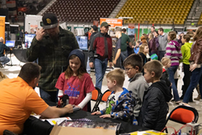 K-12 children interacting at a display table during STEM UP! event