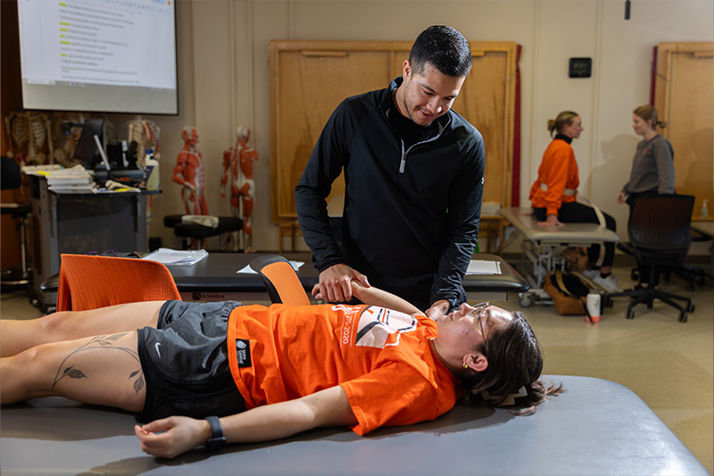 Physical Therapist Assistant studentw working with a patient in lab