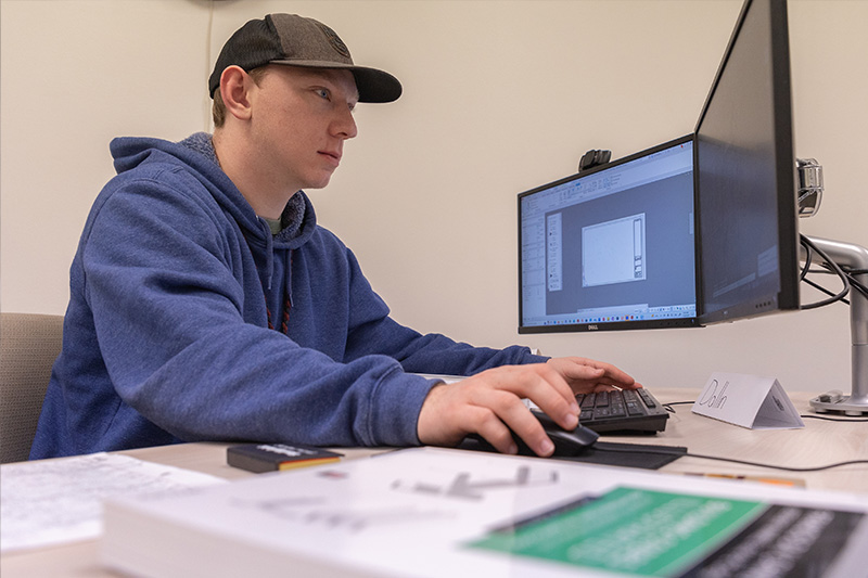 Student working on a comuter in the Computer Aided Design Drafting Technology Lab