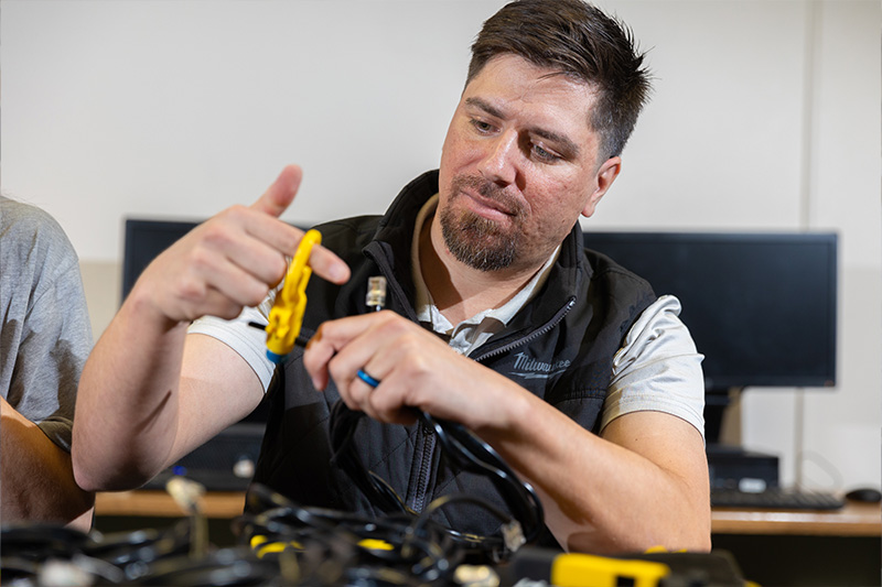 Student working with cabels in the Information Technology lab
