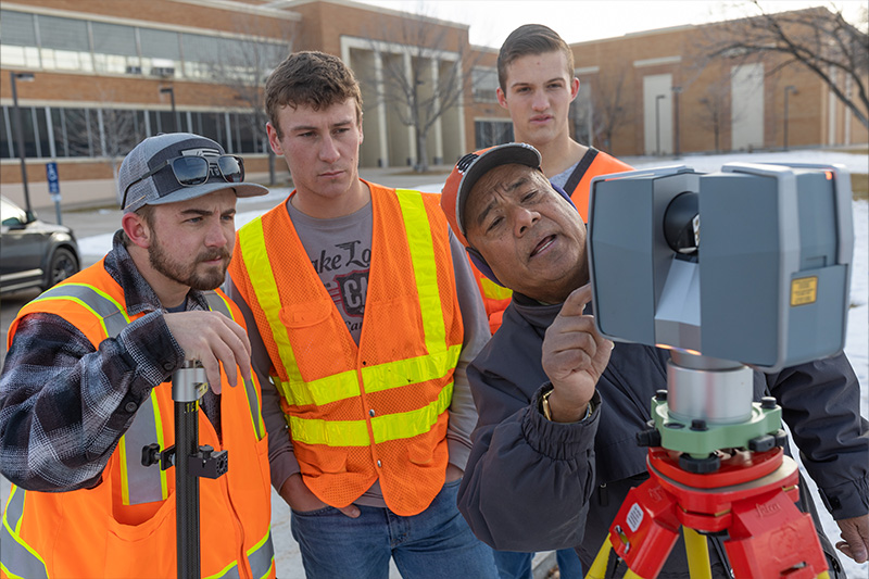 Surveying and Geomatics students and faculty working with equipment