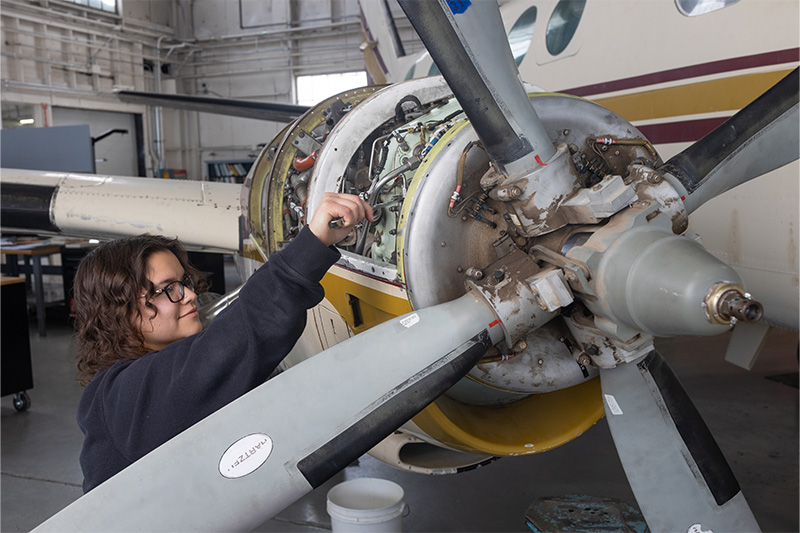 Aircraft Maintenance Technology student working on an airplane