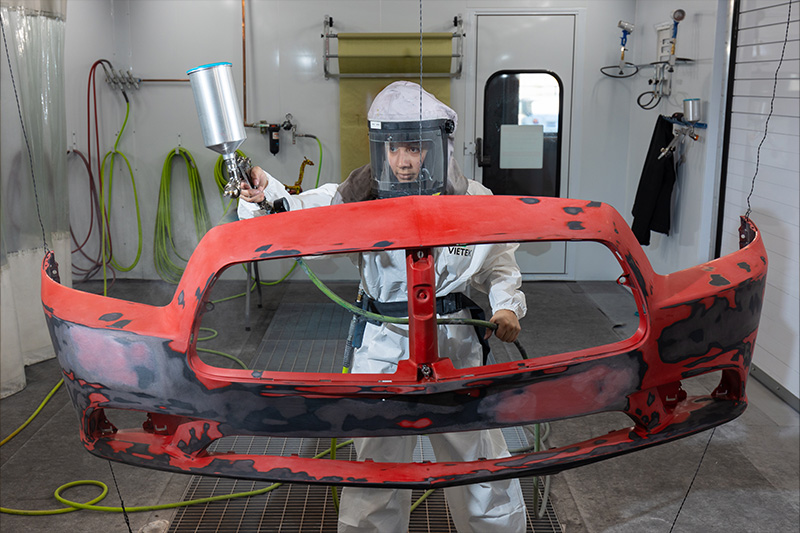 Auto Collision and Repair student painting a fender