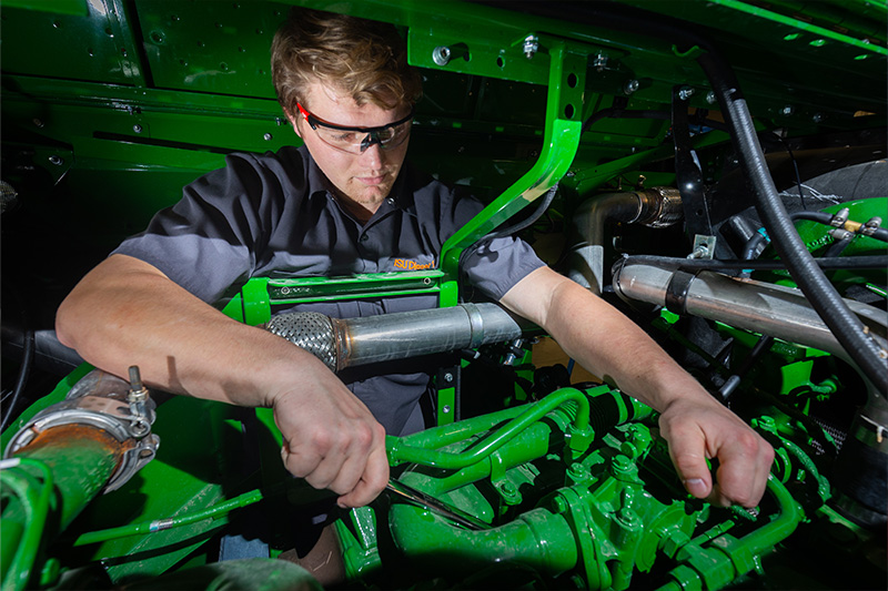 Diesel student working on a combine