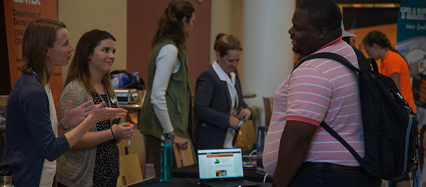 Counseling center employees talk to students at a health fair