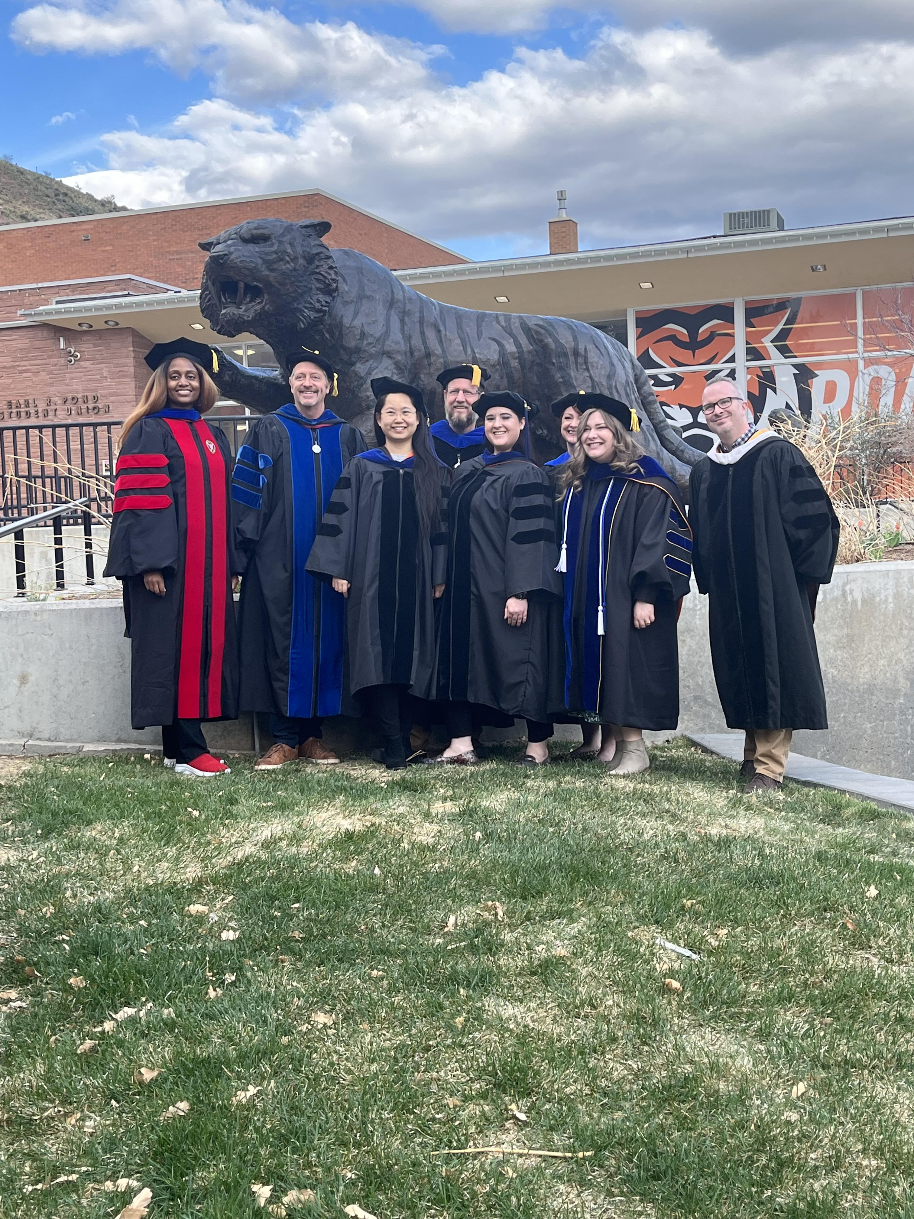 A group of doctoral graduates wearing graduation regalia
