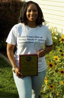 A smiling woman holding an award