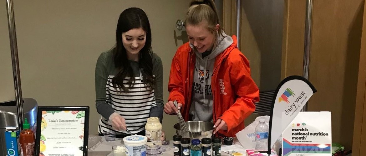 Two Nutrition and Dietetic students prepare healhy snacks at community health fair