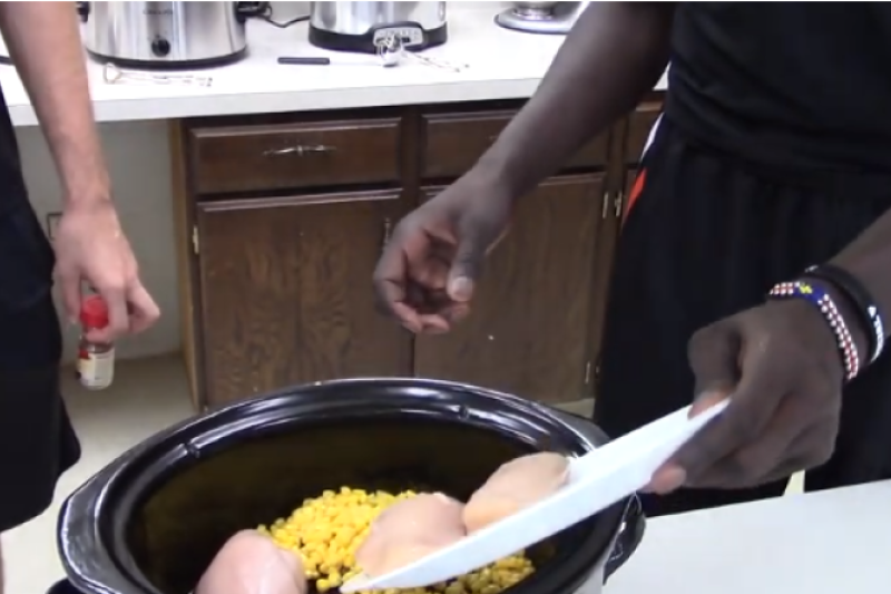 Two male basketball players participate in crock pot cooking class