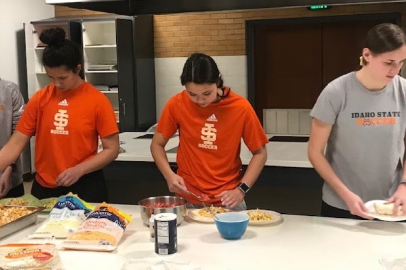 Three members of the ISU women's soccer team prepare a healthy meal in  the ISU Foods Lab