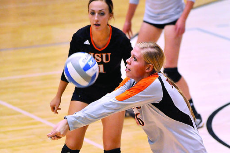 Two ISU female volleyball players, one hitting the ball