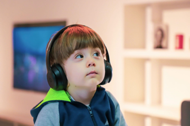 Young boy with headphones on listening