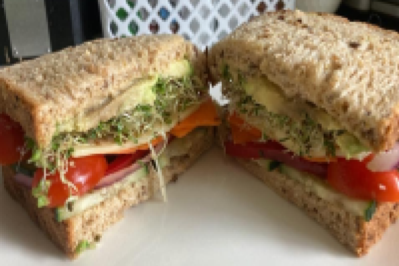 sandwich with sprouts, tomato, avocado, cheese and wheat bread