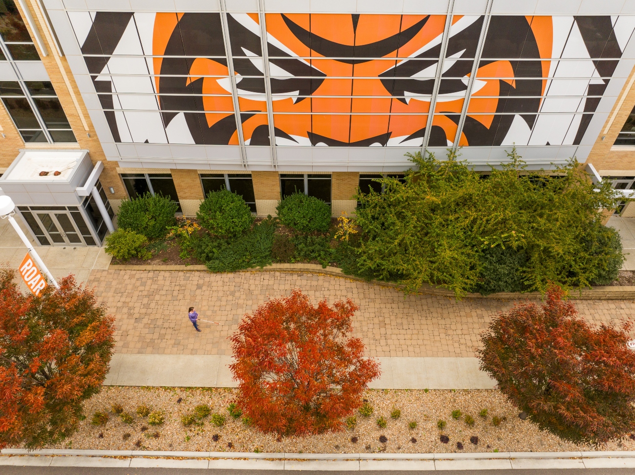 A drone photo from high above of ISU student Nicole Hill, walking with a white cane near the Rendezvous Center.