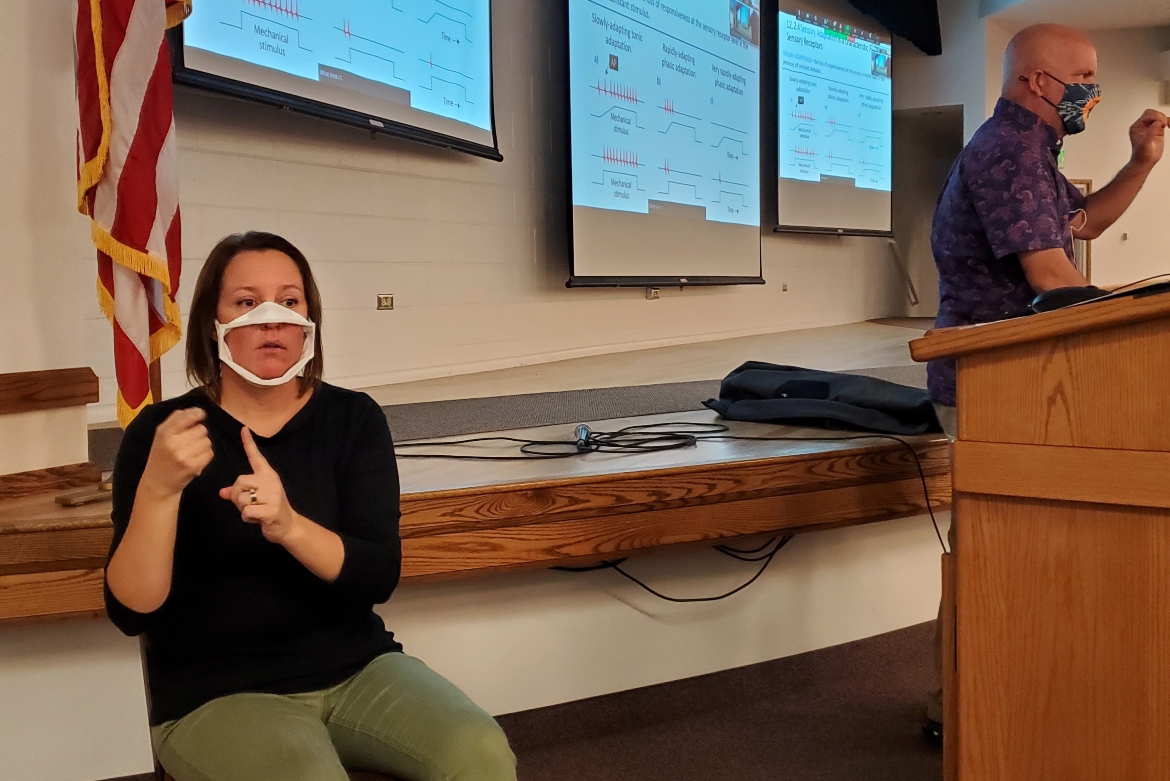 ISU's Nicole Stanton interpreting in front of a class using sign language.