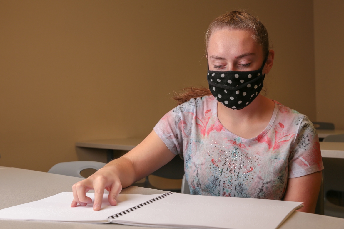 Nicole Hill reading braille.