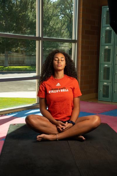 Female african american student meditating on a yoga mat