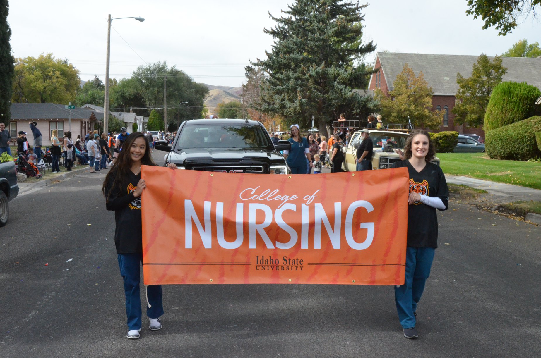 College of Nursing students walk with banner in the 2018 Homecoming parade