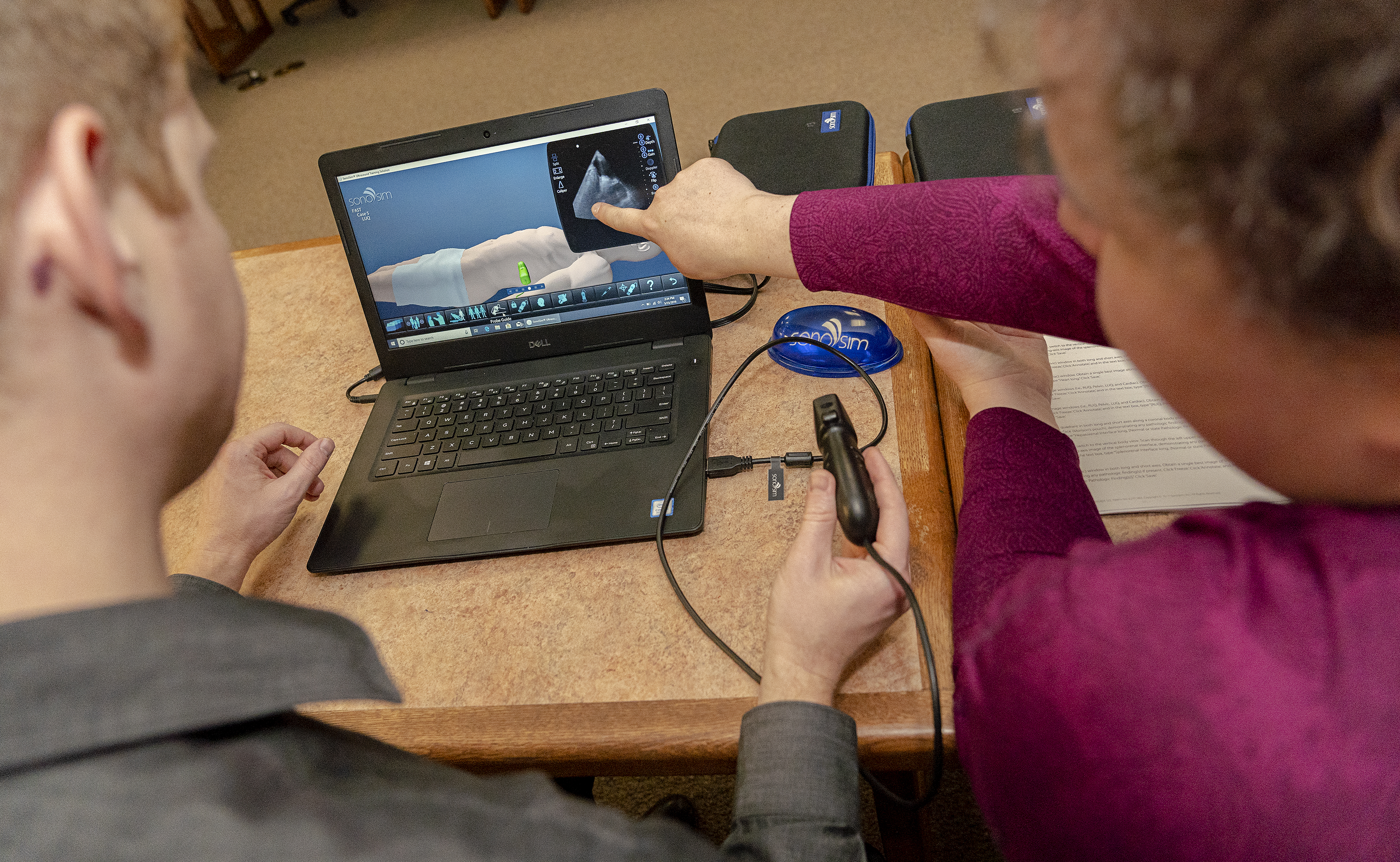 Family Medicine residents and faculty work using the SonoSim and a laptop to view sonography images of simulated patients