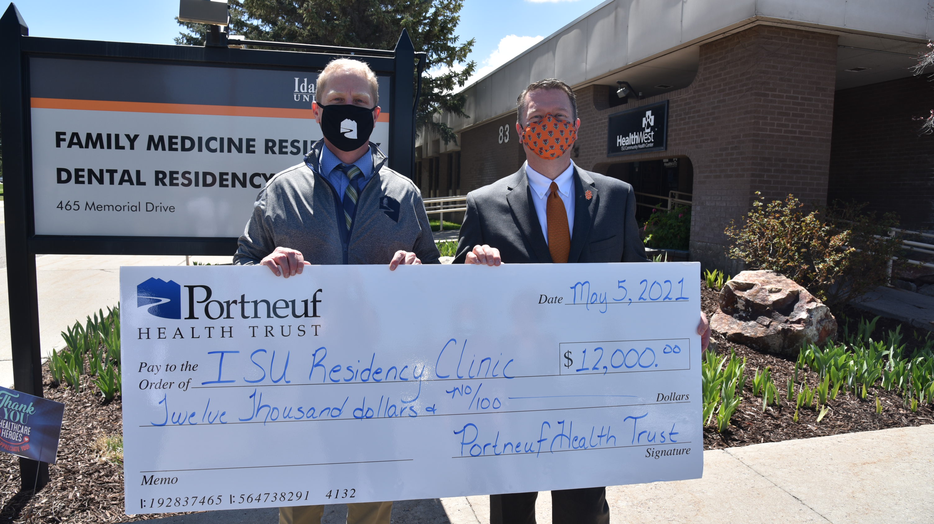 ISU President Kevin Satterlee with Portneuf Health Trust CEO Shaun Menchaca outside Health West ISU with large check for $12,000 donated by Portneuf Health Trust