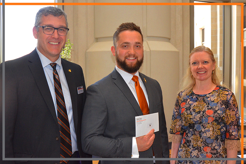 Rex Force presents Jacob Crossley with a check in the Stephens Performing Arts Center rotunda