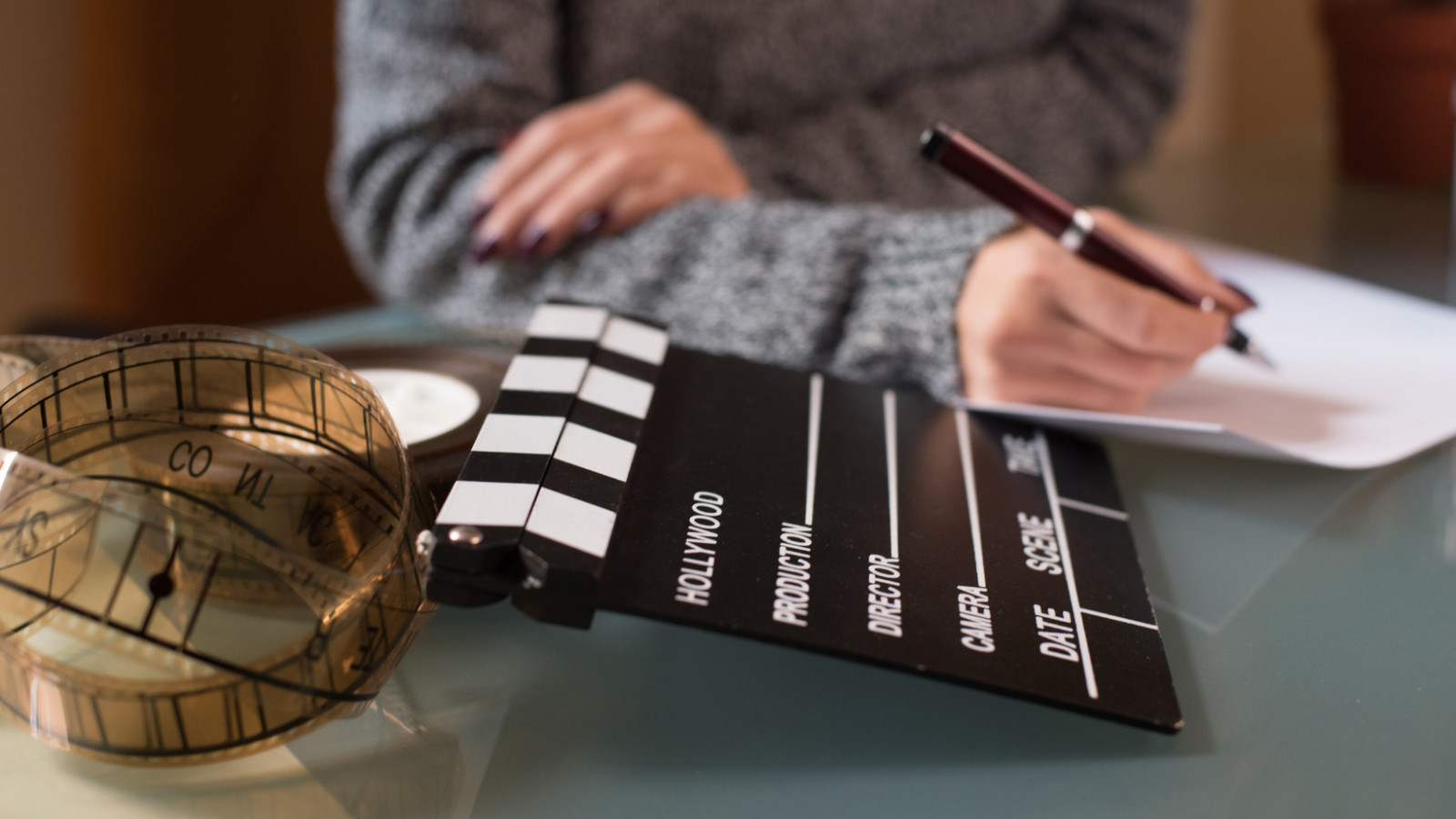 person sitting next to a film reel