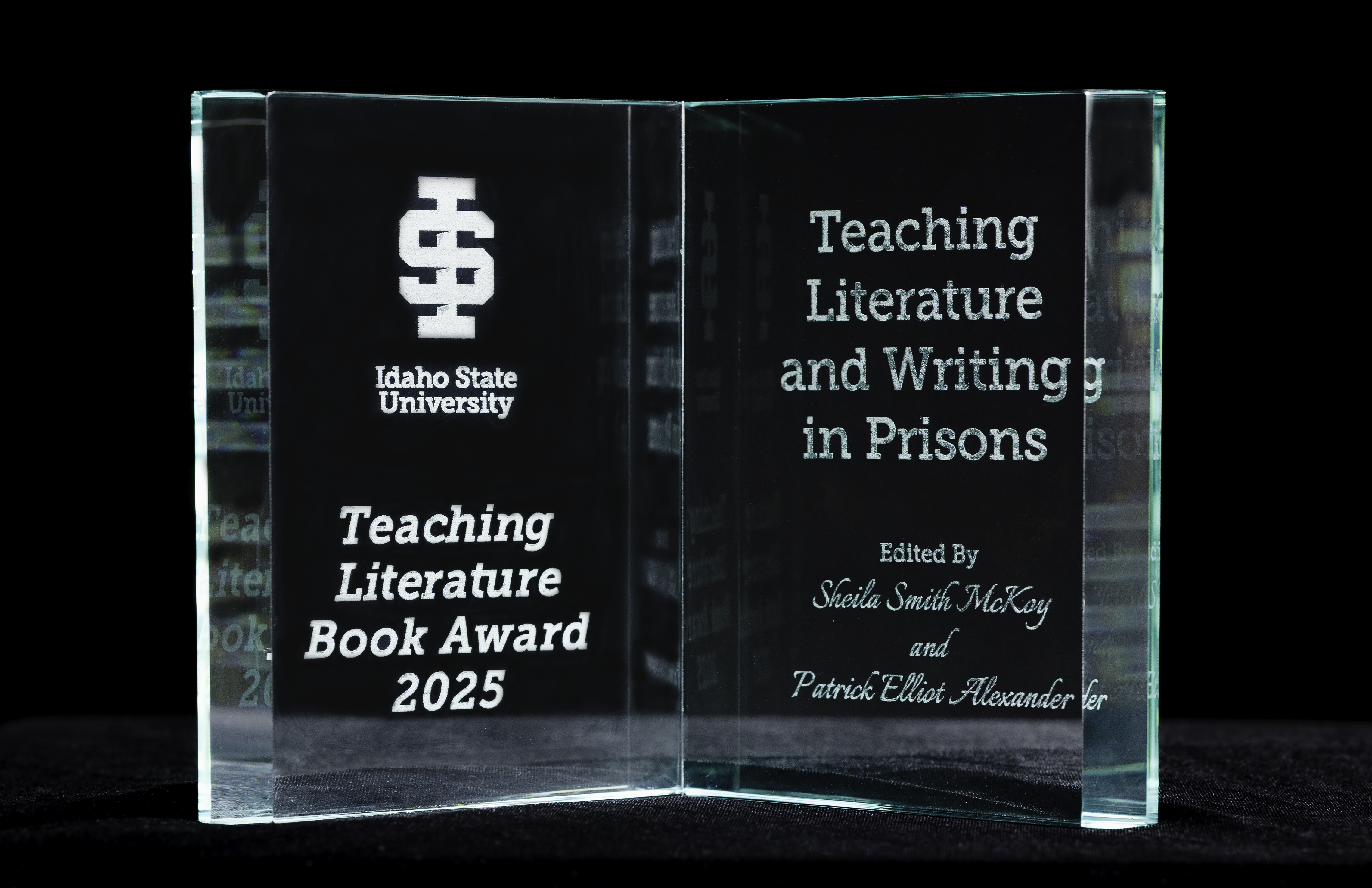 Glass award looking like a book with title of 2025 winner on it